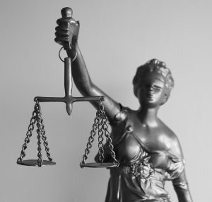 Image of a statue of Liberty holding up the scales of justice.