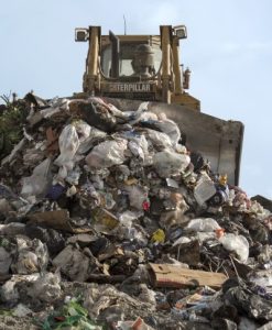 Image of a tractor moving large heaps of garbage.