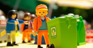 Image of a LEGO trash collector pushing a garbage bin.