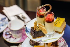 Image of a teapot with desserts on a small plate.