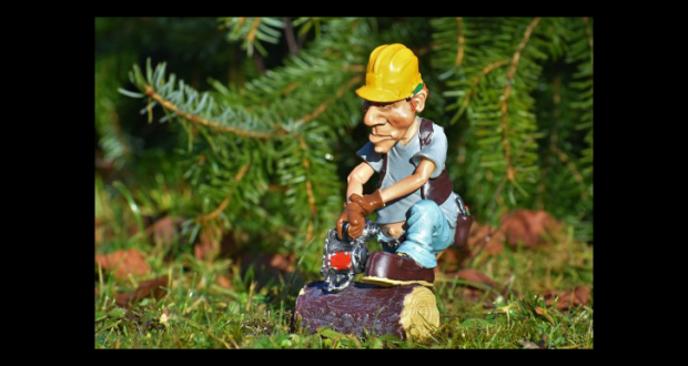 Image of a toy lumberjack figurine cutting up a log.