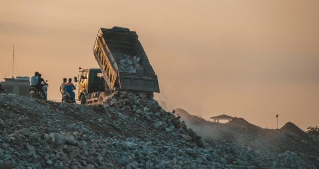 Image of a garbage truck unloading solid waste at a landfill.