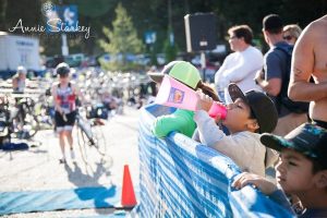 Image of young children cheering on triathletes.