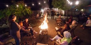 Image of people gathered around a fire while the band plays at the queens inn