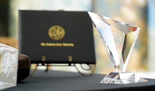Image of a diploma and crystal trophy.