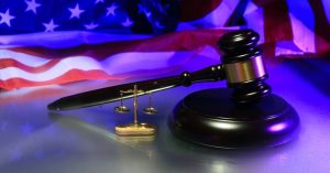 Image of a judge's gavel against a background of an American flag.