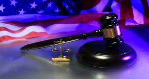 Image of a judge's gavel against a background of an American flag.