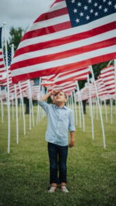Image of a young boy saluting the American flag. 