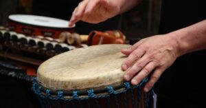 Image of a two hands playing a hand drum.