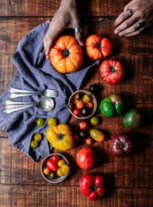 Image of a table with a group of various tomatoes on it. 