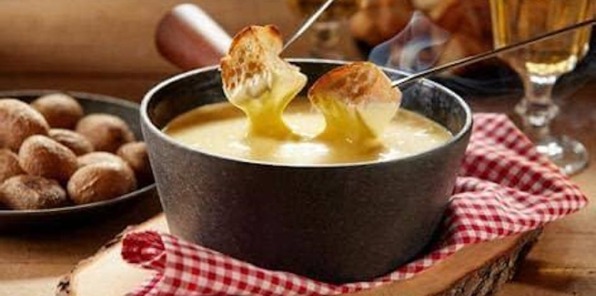 image of a fondue pot with people dipping potato chips in the sauce