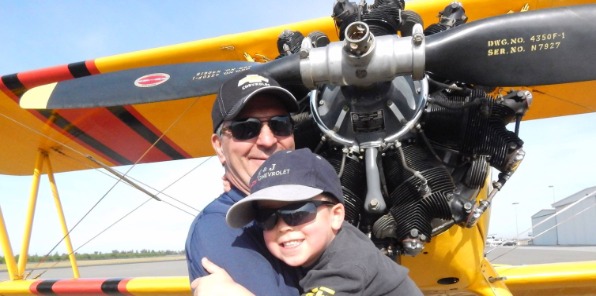 image of a man and boy in front of an airplane