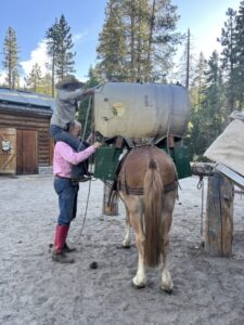 Packers Nick and Abby load up a mule before a trek across Yosemite. Photo courtesy of the National Park Service.