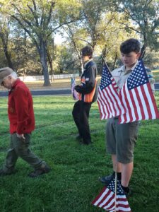 Scout Troop 357 and Lions Club placing flags at the graves of veterans