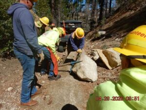 Photo of Stewards of the Sierra National Forest working on boulder that rolled across a trail.