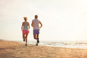 two people running on the beach