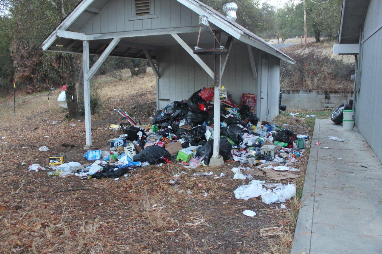 Trash piles next to house