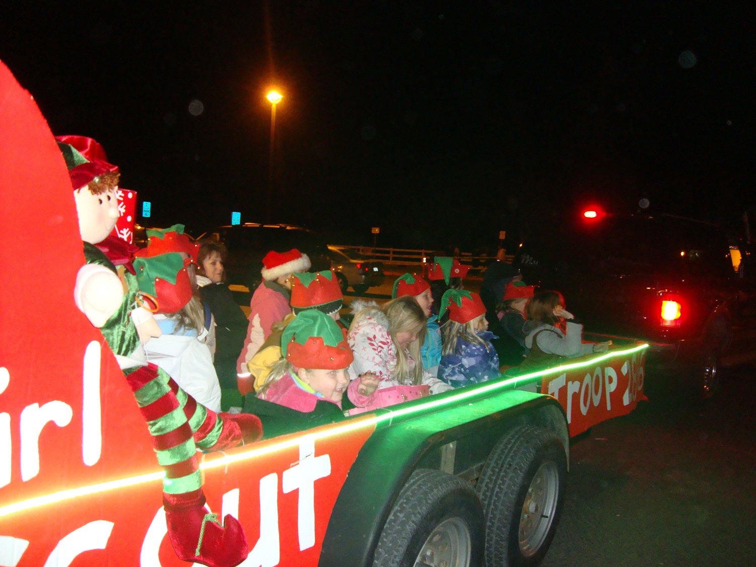 Students from Girl Scout Troop 2866 participating in the Parade of Lights Holiday Fest parade float - courtesy of Rivergold