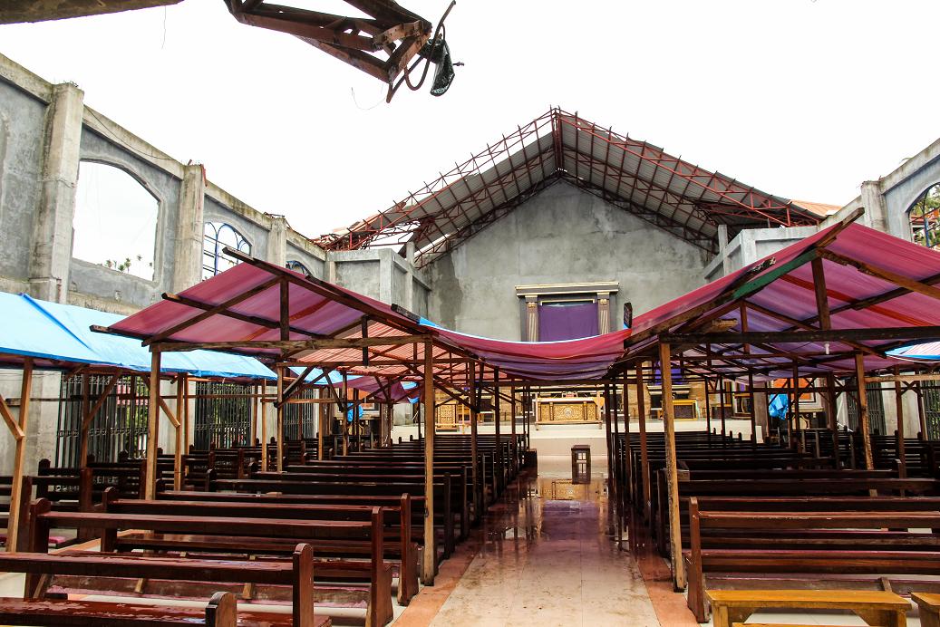 Two days before Easter worshippers can only hope for a place to stay dry under makeshift tents in the sanctuary - photo by Jay York